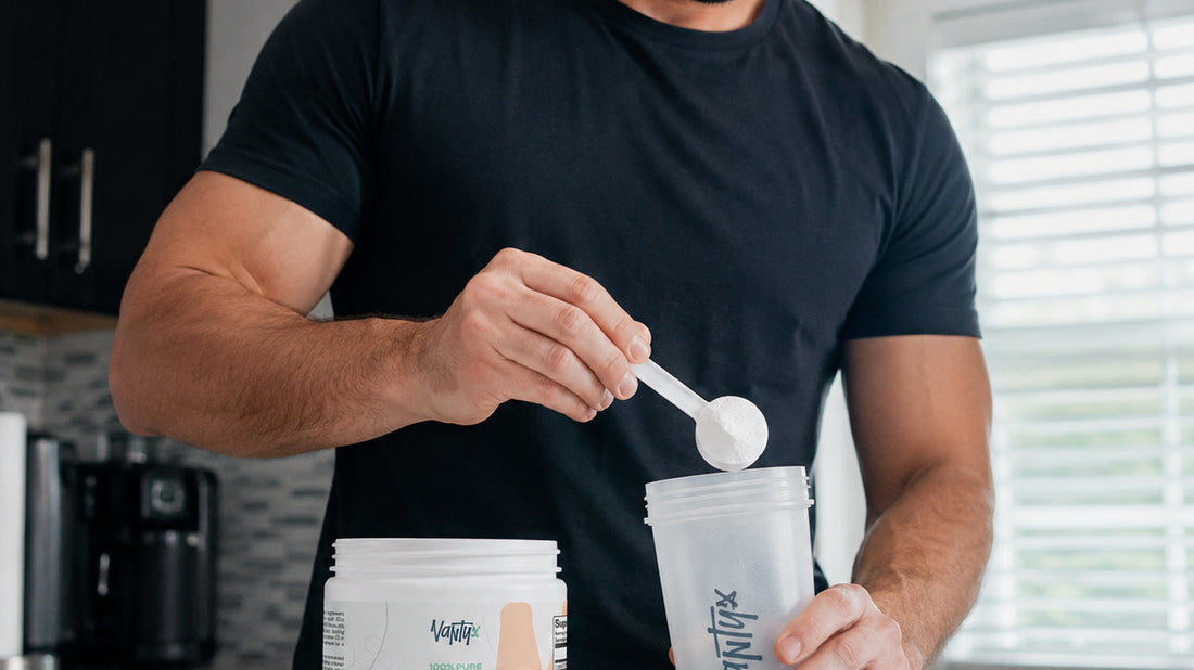 Creatine gummies vs powder: a scoop of unflavoured Vantyx creatine monohydrate powder being added to a shaker beside the 250 g container